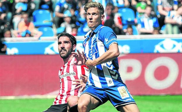 Marcos Llorente pugna por la pelota con Raúl García en Mendizorroza. /Igor Aizpuru