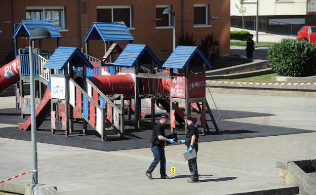 Dos policías inspeccionan el parque infantil de Arrasate en el que tuvo lugar el tiroteo.