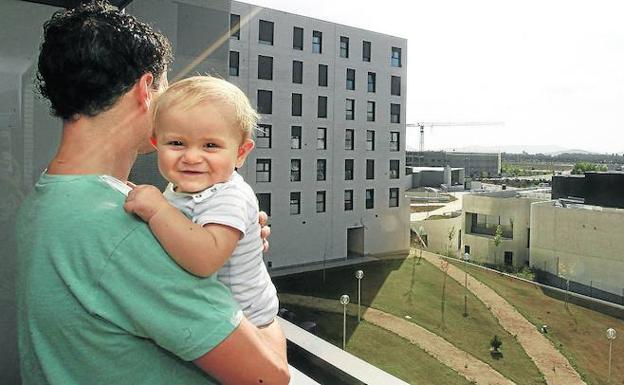Un vecino de Zabalgana sujeta a su hijo mientras observa el nuevo centro cívico del barrio.