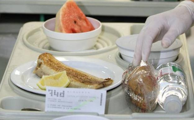 Bandeja de un hospital con pescado, galletas y fruta.
