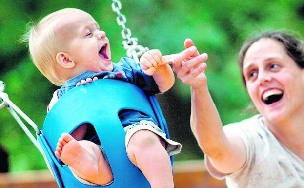 Una madre juega con su hijo en un parque infantil./ap