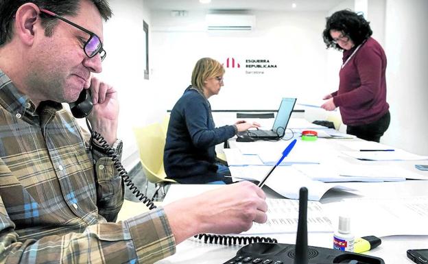 José María Vall atiende al teléfono, mientras Thais Domenech y Elvira Duran repasan varios documentos de trabajo./VICENS GIMÉNEZ