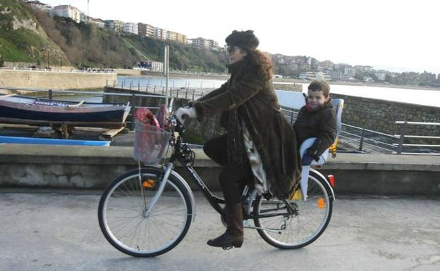 Una mujer pasea en bicicleta por el Puerto Viejo. /EL CORREO