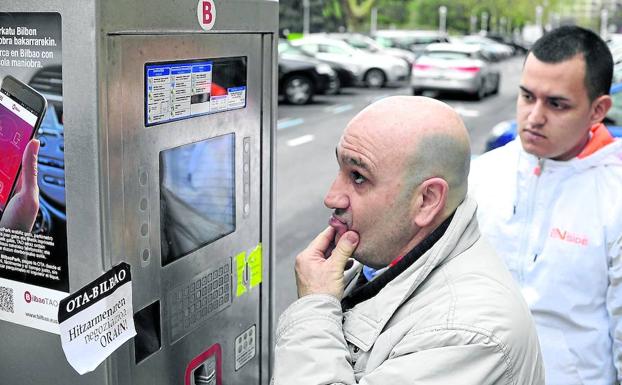 Los conductores siguen con la incertidumbre de pagar o no en los parquímetros, que aparecen llenos de pegatinas./ignacio pérez
