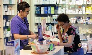 Una mujer solicita sus medicamentos en una farmacia de Bilbao./