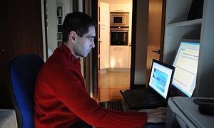 Un hombre trabaja con sus ordenadores en casa./ E.C./