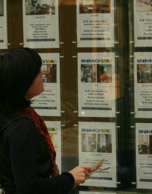 Una mujer consulta ofertas de pisos en una inmobiliaria de Vitoria. :: JESÚS ANDRADE/