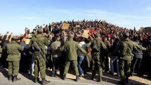 Soldados tunecinos intentan calmar los ánimos de refugiados egipcios que protestan en un campamento situado cerca de la frontera con Libia. :: REUTERS/