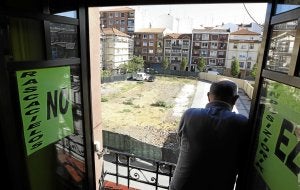 Un vecino se asoma a una ventana encartelada frente al solar que acogerá el equipamiento. ::
MIREYA LÓPEZ/