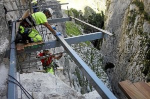 Operarios instalan la estructura de la plataforma. /Nel Acebal/