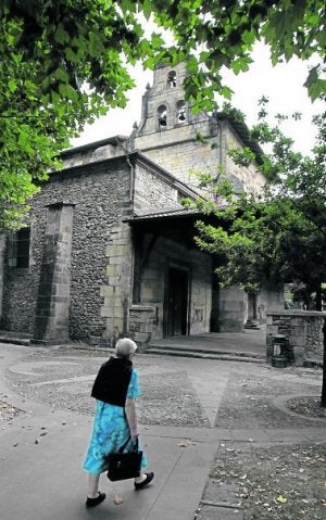 Una mujer cruza la plaza frente a la iglesia de Tabira. ::
MITXEL ATRIO/