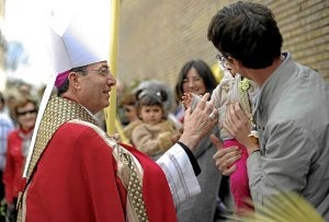 El arzobispo Francisco Pérez da la bendición a un niño. /Efe/