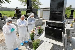 Vecinos de Fukushima rezan ante las tumbas de sus ancestros. /Afp/