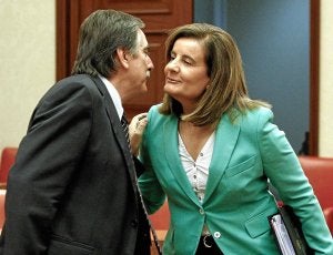 Fátima Báñez saluda a su antecesor al frente del Ministerio de Trabajo, el socialista Valeriano Gómez. /Efe/