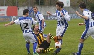 Un jugador del Portugalete cae rodeado de varios rivales. ::
XXX/