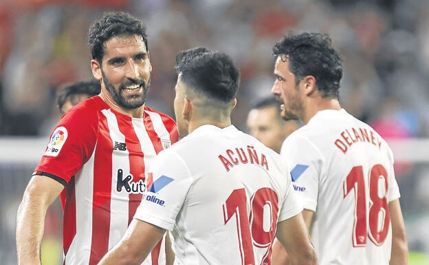 Raúl García habla con Acuña tras realizar una entrada al futbolista dle Sevilla. 