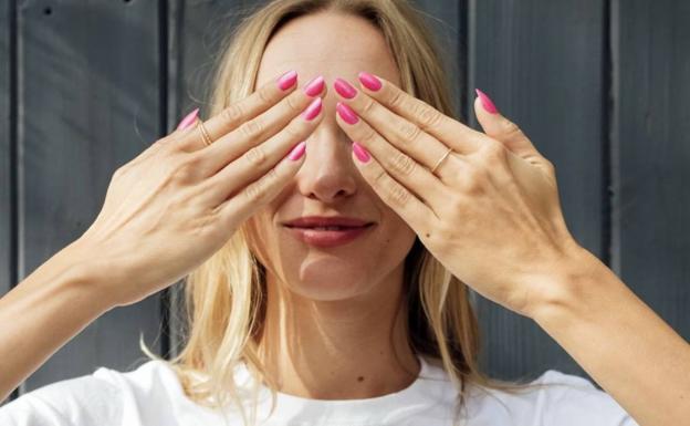 Una mujer muestra su manicura.