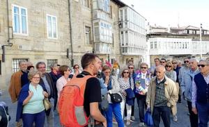 Asistentes a una visita atienden las explicaciones del guía en la plaza del Matxete./