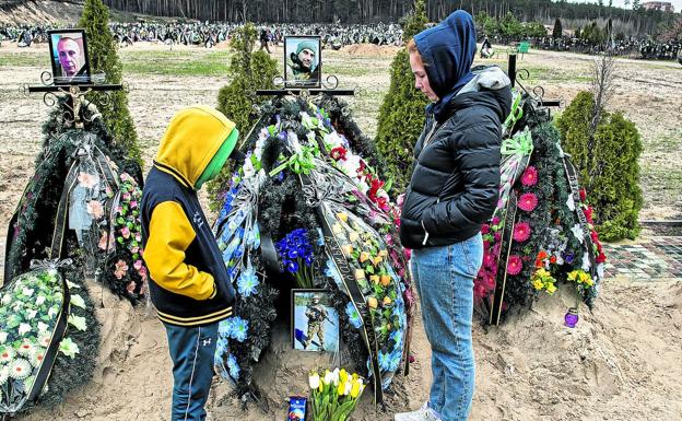 Alla Krotkikh and her son Savely Krotkikh, at his father's grave.