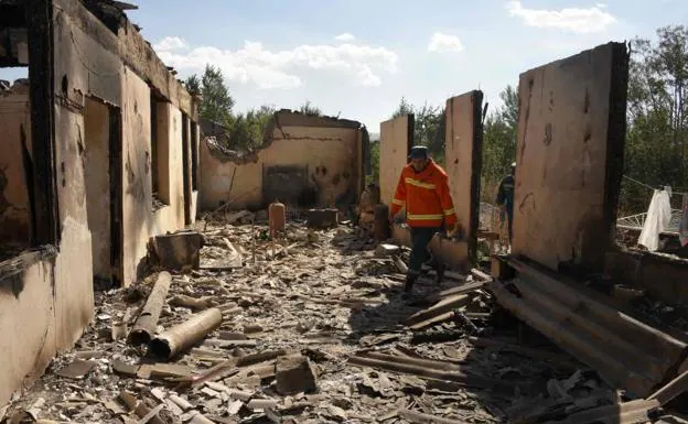 Firefighters examine the ruins of a house bombed by Azerbaijan in the Armenian city of Sotk.