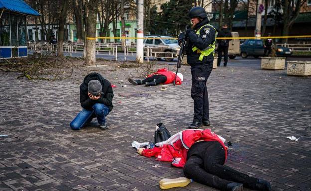 A man mourns over the body of a woman killed after a Russian bombing raid on the Ukrainian city of Kherson on December 24, which killed five people and wounded 20.